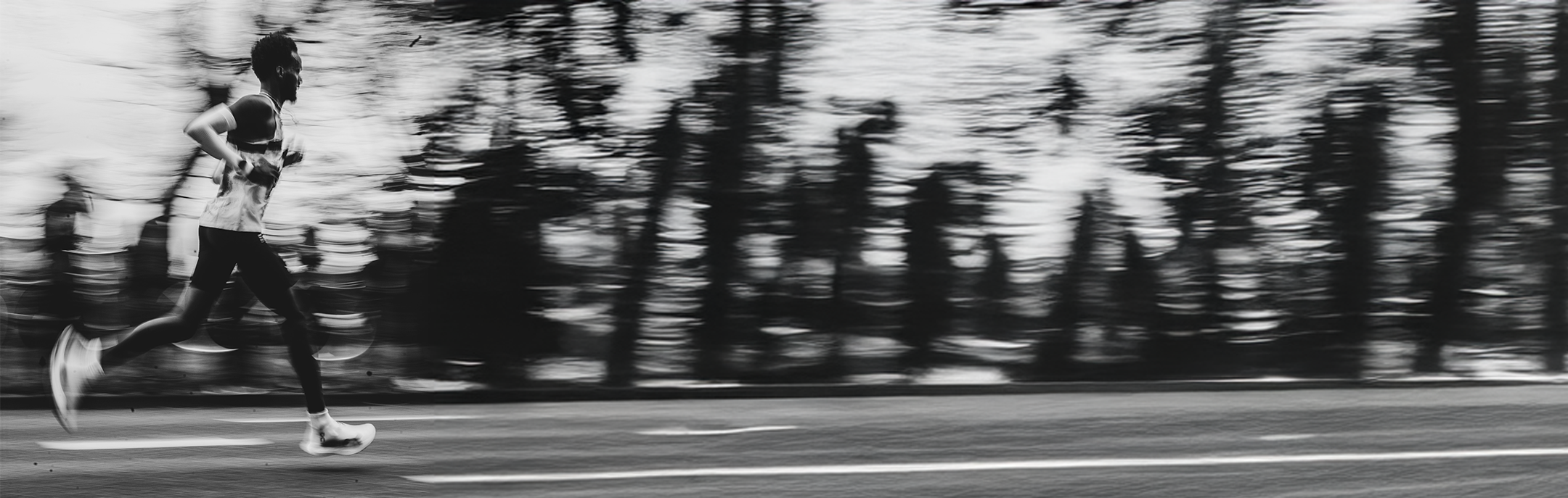 Person running on a road with trees in the background