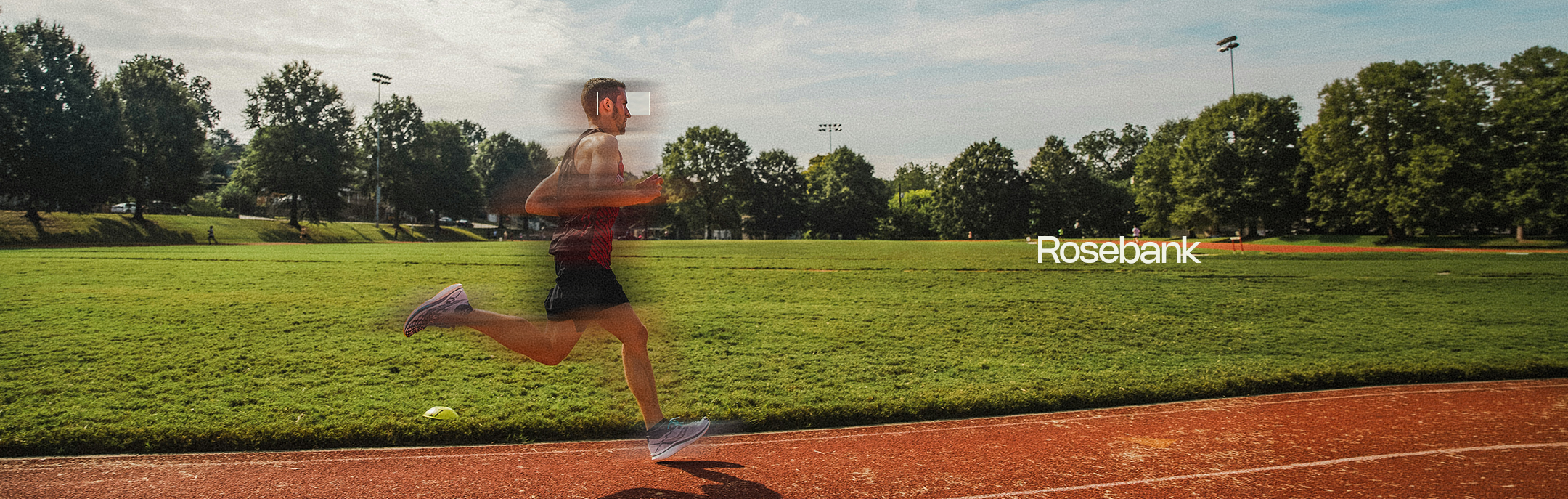 Person running on a track with trees in the background, featuring the brand 'Rosebank'.